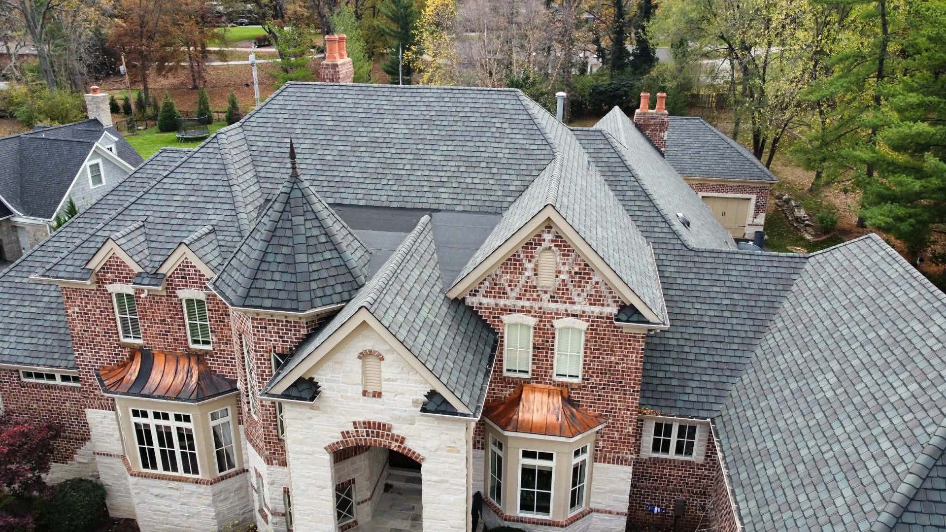 Luxury brick and stone home with designer shingles and copper bay roofing