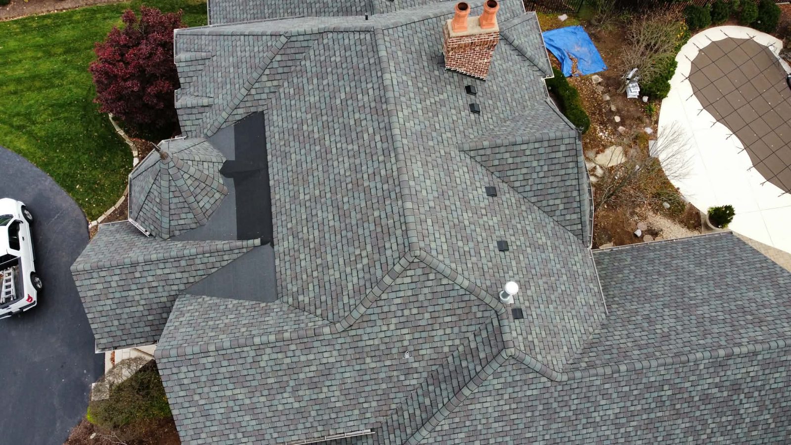 Aerial view of a designer shingle roof installed by ArchTop Roofing, with the ArchTop truck on site